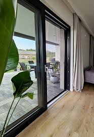 Moskitiera drzwiowa przesuwna w salonie – praktyczne i estetyczne rozwiązanie do dużych przeszkleń z wyjściem na taras.